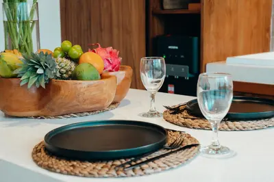 a table with two glasses and a bowl of fruit at La Payesa 2 in Canggu
