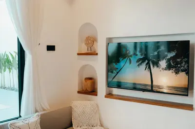 a living room with a flat screen tv on a wall at La Payesa 2 in Canggu
