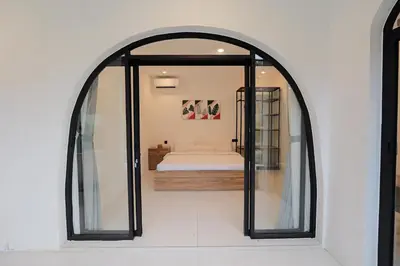 an arched mirror in a room with a bed at 4BR Modern Villa walking dist to Sidewalk Jimbaran in Jimbaran