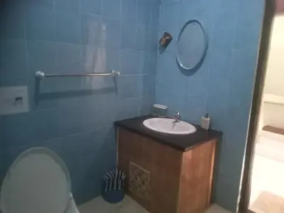 a bathroom with a sink and a mirror and a toilet at Villa Private In Kuta Bali in Kuta