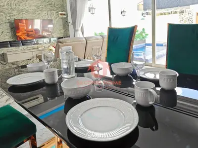 a table with plates and wine glasses on it at Luxury 3BR Krobokan Villa B Pool&Wi-Fi in Kerobokan