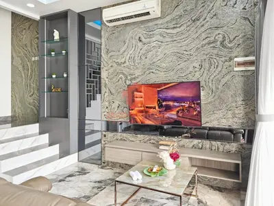a living room with a stone wall with a fireplace at Luxury 3BR Krobokan Villa B Pool&Wi-Fi in Kerobokan