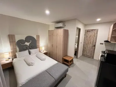 a bedroom with a large bed and a television at Luminera Bali Apartment in Nusa Dua