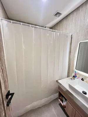 a bathroom with a shower curtain and a sink at Luminera Bali Apartment in Nusa Dua
