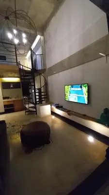 a living room with a large television and a couch at Arzella Apartment in Seminyak