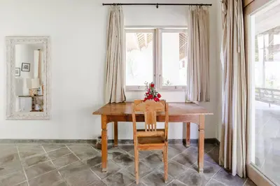 a table and chair in a room with a window at Five Star Reviews, Airbnb Plus, Awesome Location in Seminyak