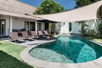 a swimming pool with chairs and a house at Five Star Reviews, Airbnb Plus, Awesome Location in Seminyak