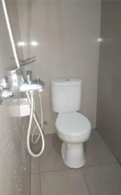 a bathroom with a white toilet and a shower at Omah Chandra in Pesanggaran
