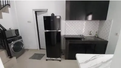 a kitchen with a refrigerator and a washing machine at Omah Chandra in Pesanggaran