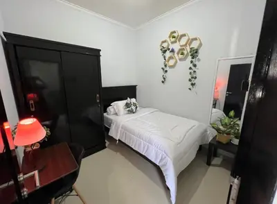 a bedroom with a bed and a black cabinet at Omah Chandra in Pesanggaran