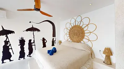 a bedroom with a bed with a wall mural of people at Minimalist & Bohemian 2Br Villa in Seminyak in Seminyak