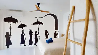 a bedroom with a wall mural of people with umbrellas at Minimalist & Bohemian 2Br Villa in Seminyak in Seminyak