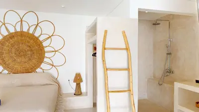 a bedroom with a ladder next to a bed and a shower at Minimalist & Bohemian 2Br Villa in Seminyak in Seminyak