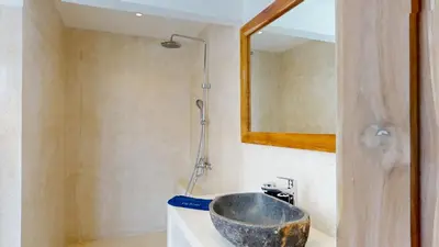 a bathroom with a bowl sink and a mirror at Minimalist & Bohemian 2Br Villa in Seminyak in Seminyak