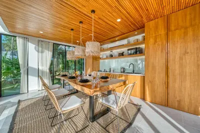 a dining room with a wooden ceiling and a table and chairs at New! Designer Arch Villa with pool near Seminyak in Kerobokan