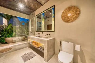 a bathroom with a sink and a toilet and a mirror at New Sleek 1BR Retreat with Pool Near Seminyak in Kerobokan