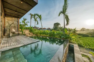 an infinity pool in a villa with palm trees at New Sleek 1BR Retreat with Pool Near Seminyak in Kerobokan