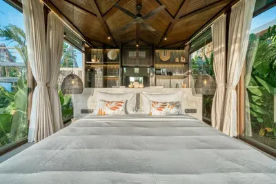 a bedroom with a large bed with large windows at New Sleek 1BR Retreat with Pool Near Seminyak in Kerobokan