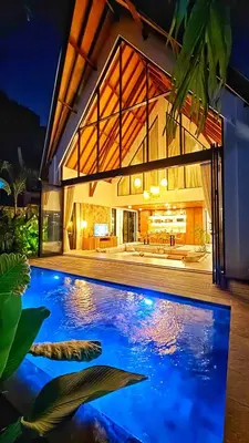 a swimming pool in front of a house at New Tranquil Jungle View Villa in Kerobokan in Kerobokan
