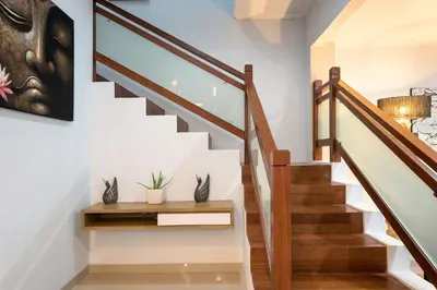 a staircase with white walls and wooden railings at 5 Reviews, Huge Savings Best Locale In Seminyak in Badung