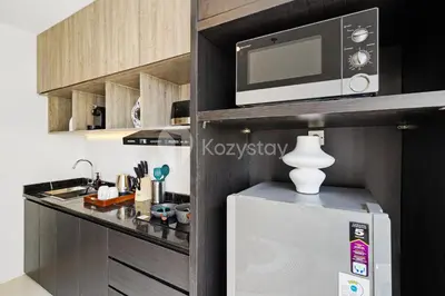 a kitchen with a microwave and a refrigerator at Caraya by Kozystay - Nusa Dua in Nusa Dua
