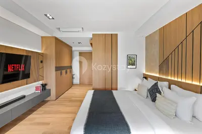 a bedroom with a large bed and a tv at Levora by Kozystay - Nusa Dua in Nusa Dua
