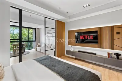 a bedroom with a bed and a tv on a wall at Levora by Kozystay - Nusa Dua in Nusa Dua