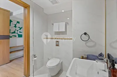 a white bathroom with a toilet and a sink at Levora by Kozystay - Nusa Dua in Nusa Dua