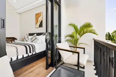 a bedroom with a bed and a chair on a balcony at Manisha Villa by Kozystay - Seminyak in Seminyak