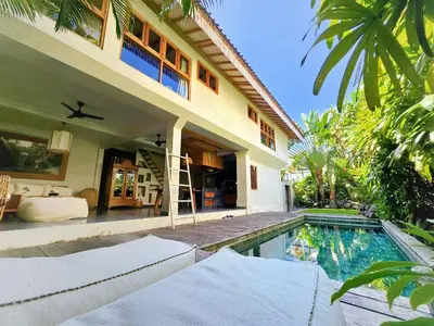 a house with a swimming pool in front of a house at Villa Hibou - New Tropical Luxury 2BR near Canggu in Canggu