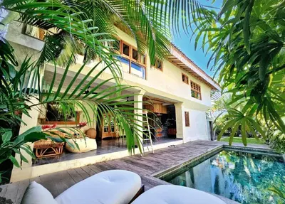 a house with a swimming pool in front of a house at Villa Hibou - New Tropical Luxury 2BR near Canggu in Canggu
