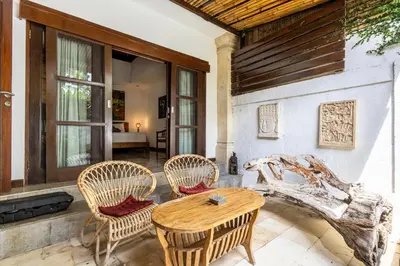 a patio with three chairs and a wooden table at Seminyak Most Wanted Villa for family vacation in Seminyak