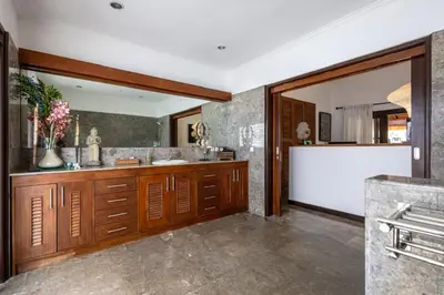 a bathroom with wooden cabinets and a sink in it at Seminyak Most Wanted Villa for family vacation in Seminyak