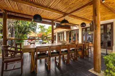 a dining room with a long wooden table and chairs at Seminyak Most Wanted Villa for family vacation in Seminyak