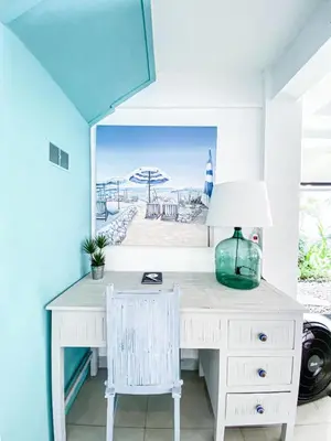 a white desk with a lamp and a picture of the beach at Villa Drupadi 16 in Seminyak