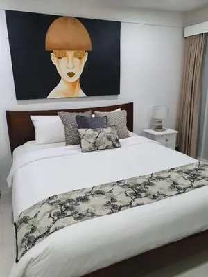 a bedroom with a large bed with a painting on the wall at Villa Drupadi 16 in Seminyak