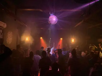 a crowd of people dancing in a room with lights at Da Housetel Kuta in Kuta