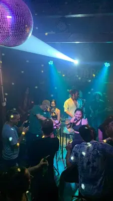 a group of people sitting in a room with a band at Da Housetel Kuta in Kuta