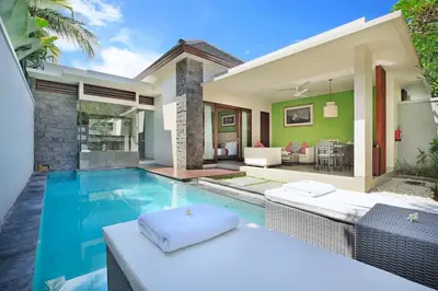 a villa with a swimming pool and a house at Royal Samaja Villas in Seminyak