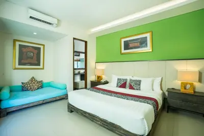 a bedroom with a bed and a bench in it at Royal Samaja Villas in Seminyak