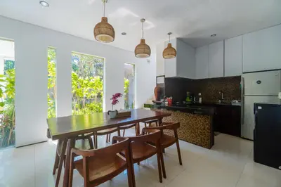 a kitchen with a wooden table and some chairs at Villa C31 Seminyak in Seminyak