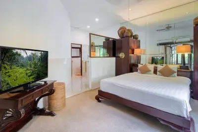 a bedroom with a bed and a flat screen tv at 3BR Seminyak Oasis, Sleeps 6, Walk to RestBars in Seminyak