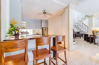 a kitchen with wooden chairs and a counter top at 3BR Seminyak Oasis, Sleeps 6, Walk to RestBars in Seminyak