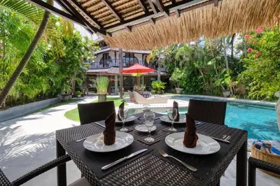 a table with two plates of food on it next to a pool at 3BR Seminyak Oasis, Sleeps 6, Walk to RestBars in Seminyak