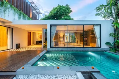 a home with a swimming pool and a house at Villa Narda Seminyak by Nagisa Bali in Legian