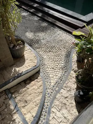a cobblestone walkway with potted plants on it at Karmani Villa Managed by Alyssa Villa Management in Ujung