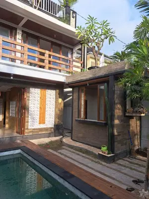 a house with a swimming pool next to a building at Karmani Villa Managed by Alyssa Villa Management in Ujung