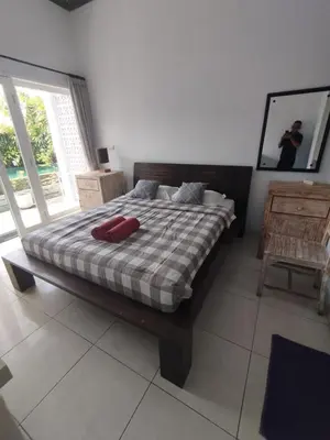a bedroom with a bed with a red pillow on it at Deluxe room near seminyak beach in Seminyak