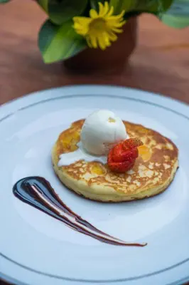 a pancake with a ice cream and a strawberry on a plate at Deluxe room near seminyak beach in Seminyak