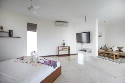 a white living room with a bed and a tv at Villa K Seminyak by Premier Hospitality Asia in Seminyak